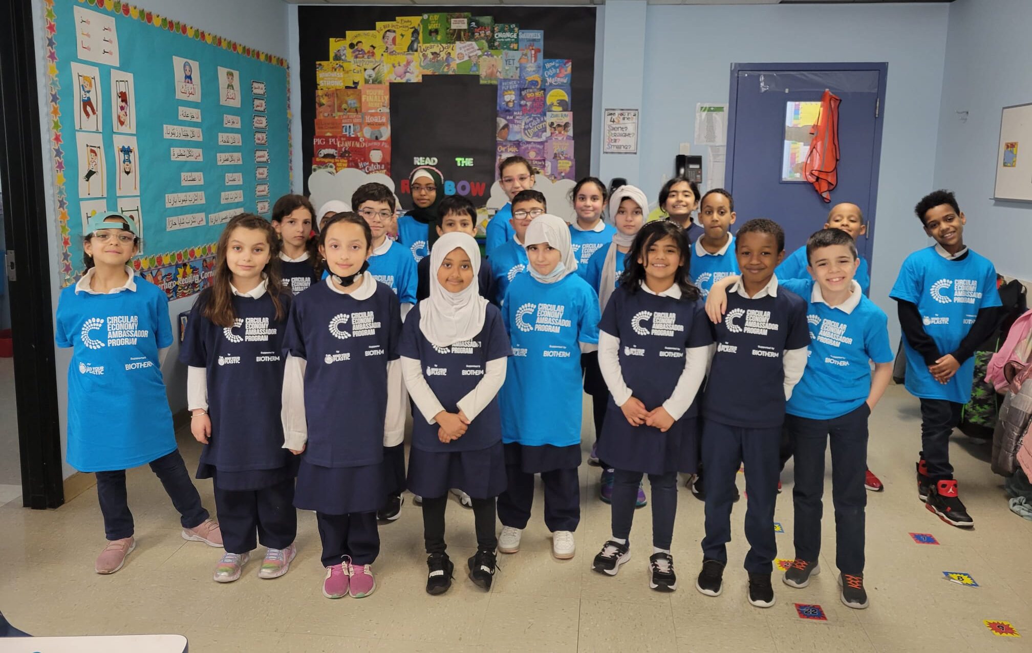 Children in blue shirts at Calgary Islamic School, engaged in MYP's Circular Economy Ambassador Program, standing in a classroom.